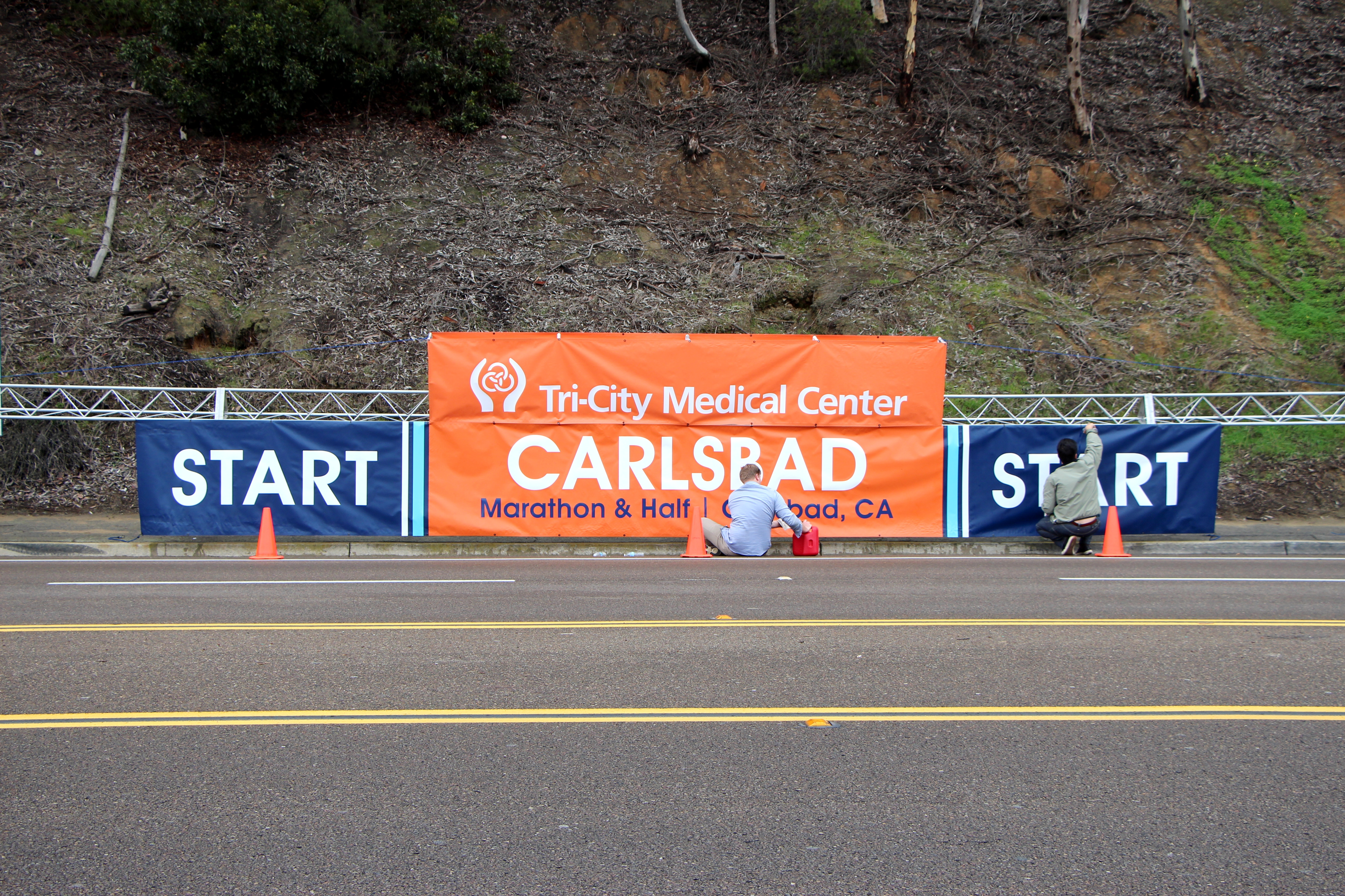 Workers clean the sign used at the Start of the Carlsbad Half Marathon